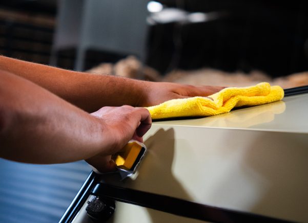 A person cleaning the hood of a car with caravan ceramic coating.